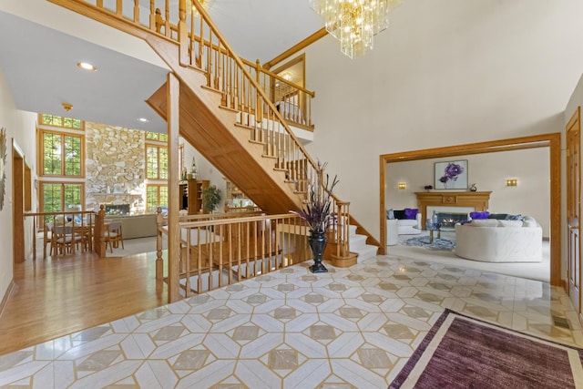 9 Forest Ln, South Barrington, IL 60010 - interior space with wood finished floors, a warm lit fireplace, a towering ceiling, and an inviting chandelier