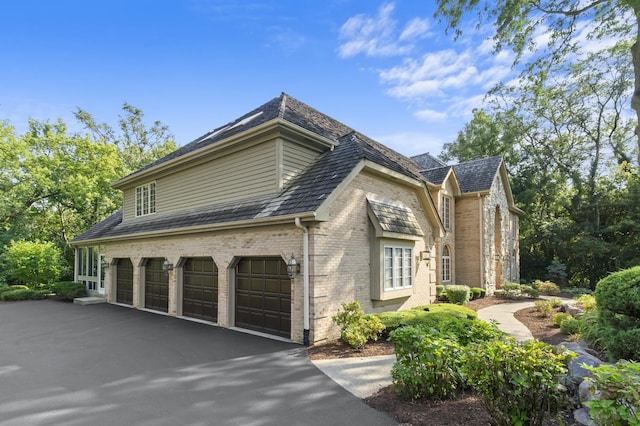 9 Forest Ln, South Barrington, IL 60010 - view of home's exterior featuring brick siding, driveway, and an attached garage