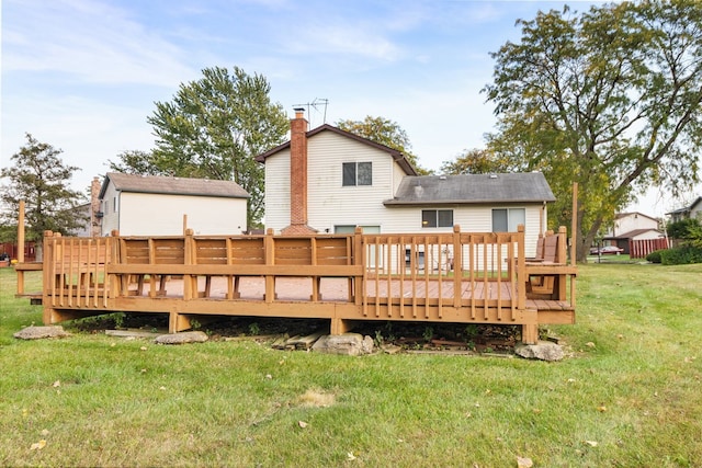 rear view of property with a yard, a chimney, and a wooden deck