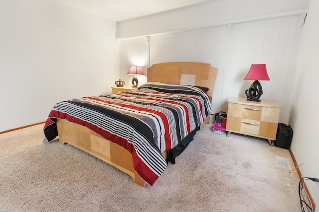 bedroom with light colored carpet and baseboards