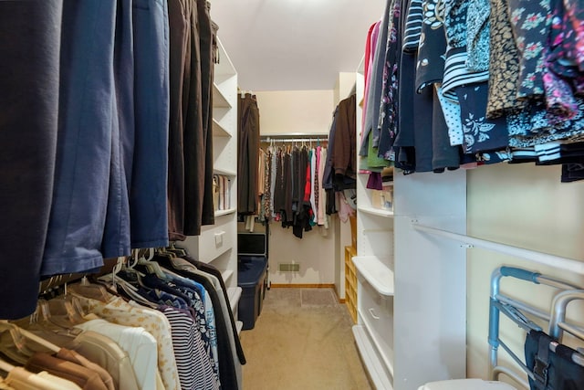 walk in closet featuring light colored carpet