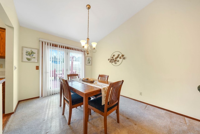 dining space with light carpet, vaulted ceiling, a notable chandelier, and baseboards