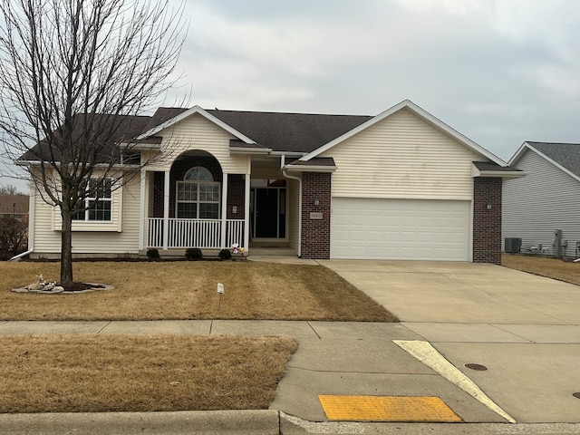 ranch-style home featuring a garage, driveway, central AC, and brick siding