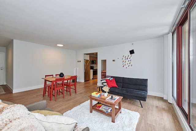 living area featuring light wood-style flooring and baseboards