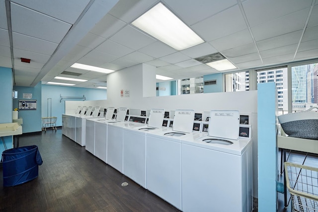 common laundry area with washer and dryer and dark wood-type flooring