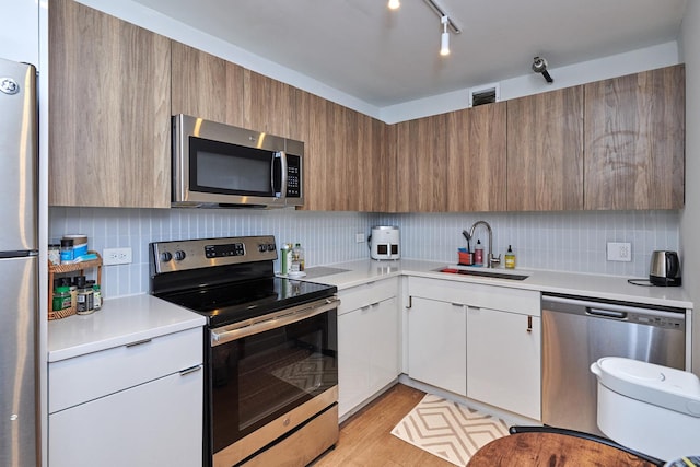 kitchen with appliances with stainless steel finishes, white cabinets, and light countertops