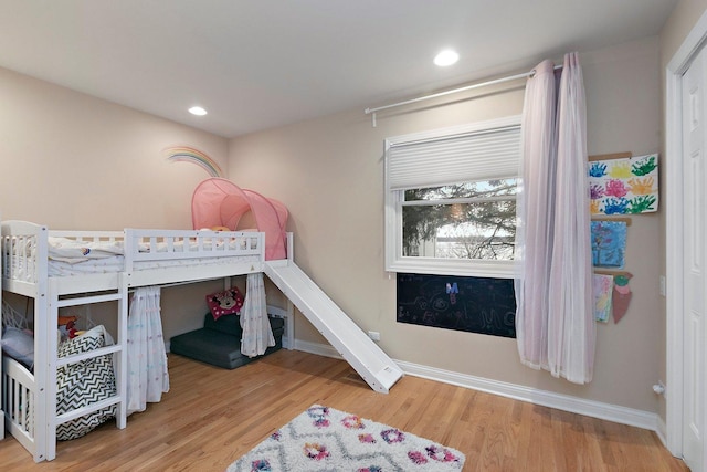 bedroom with recessed lighting, wood finished floors, and baseboards