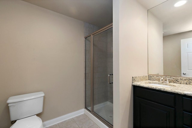 bathroom with toilet, a stall shower, vanity, baseboards, and tile patterned floors