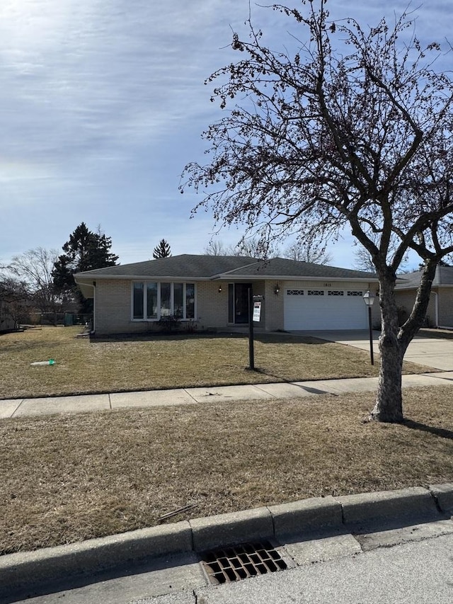 view of front of property with a garage, driveway, and a front lawn