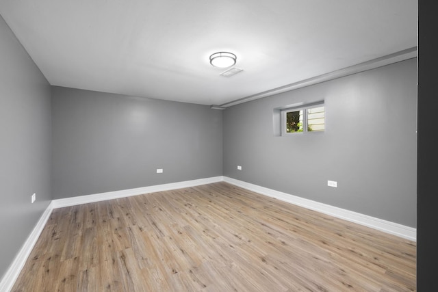 empty room featuring light wood finished floors, visible vents, and baseboards