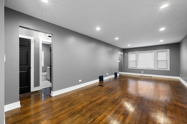 empty room with recessed lighting, dark wood finished floors, visible vents, and baseboards