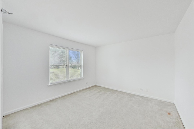 carpeted empty room with baseboards