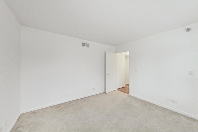 unfurnished room featuring carpet flooring, visible vents, and baseboards