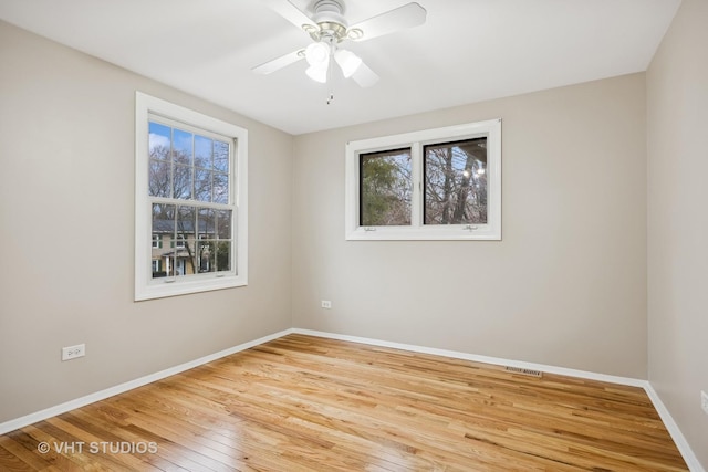 empty room with a ceiling fan, baseboards, and hardwood / wood-style flooring