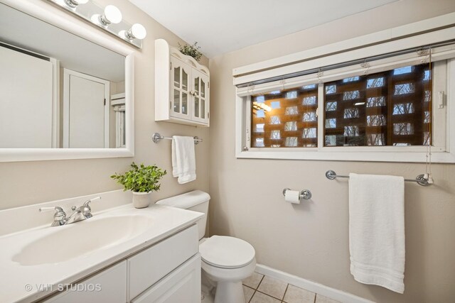 half bath featuring toilet, tile patterned flooring, baseboards, and vanity