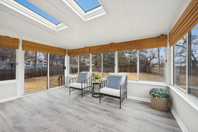 unfurnished sunroom with vaulted ceiling with skylight and a wealth of natural light