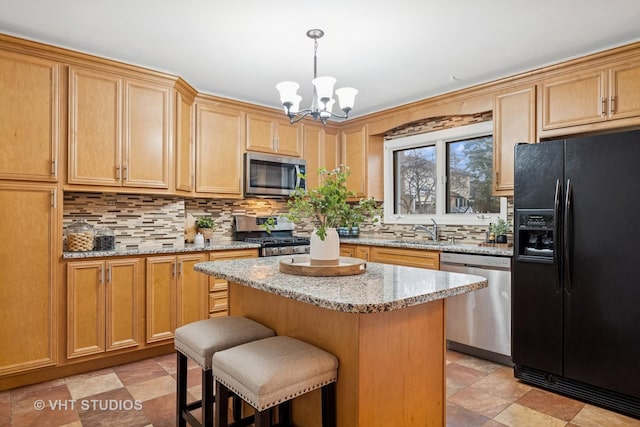 kitchen with stainless steel appliances, a kitchen island, a sink, backsplash, and a kitchen bar