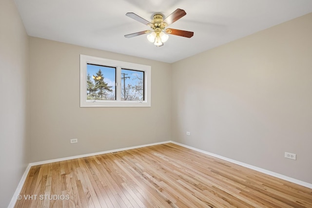 empty room with ceiling fan, light wood-type flooring, and baseboards