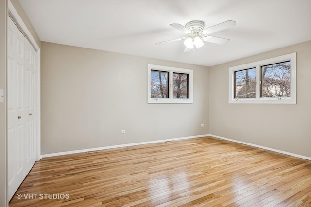 unfurnished bedroom featuring light wood-style floors, a closet, ceiling fan, and baseboards