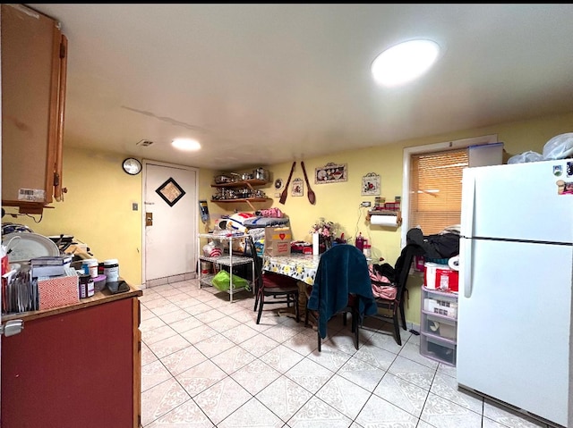 kitchen featuring light tile patterned floors and freestanding refrigerator