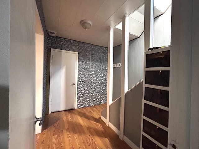 corridor with wallpapered walls and wood finished floors