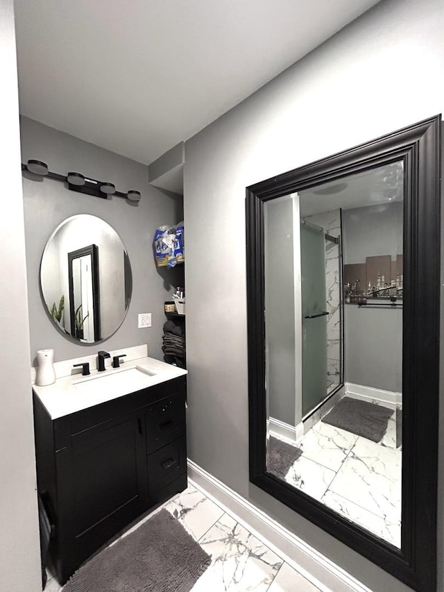 full bathroom featuring vanity, a shower stall, baseboards, and marble finish floor