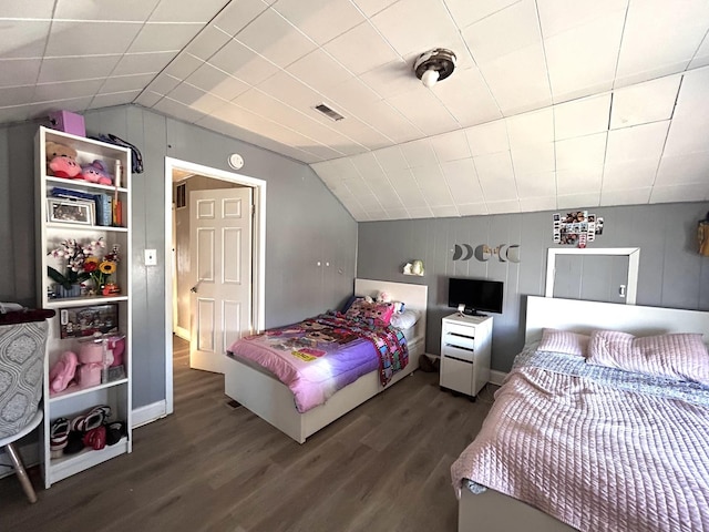 bedroom with dark wood-style floors, visible vents, and lofted ceiling