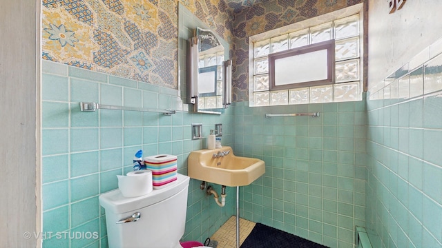 1222 Austin St, Evanston, IL 60202 - half bathroom with tile walls, a sink, toilet, a wainscoted wall, and wallpapered walls