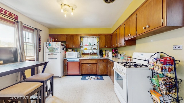 1222 Austin St, Evanston, IL 60202 - kitchen featuring white appliances, brown cabinets, a sink, and light countertops