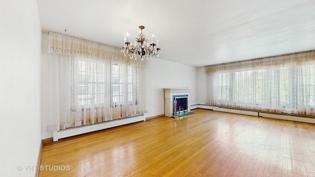 1222 Austin St, Evanston, IL 60202 - unfurnished living room with a baseboard heating unit, hardwood / wood-style floors, a chandelier, and a fireplace with flush hearth