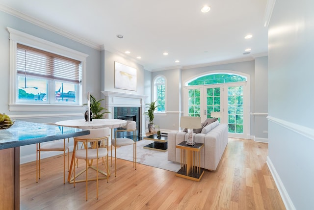 living room with a high end fireplace, light wood-style floors, and a wealth of natural light