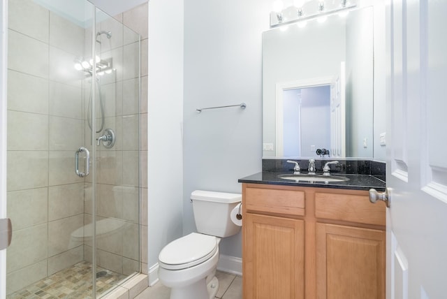 bathroom with a shower stall, baseboards, toilet, tile patterned floors, and vanity