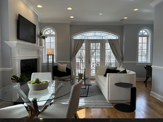 living room with wood finished floors, crown molding, and a healthy amount of sunlight