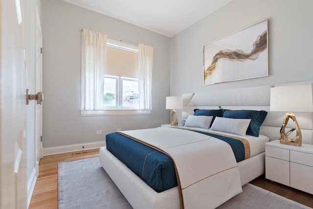 bedroom featuring baseboards and light wood finished floors