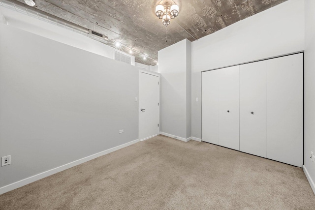 unfurnished bedroom with visible vents, a closet, light colored carpet, and baseboards