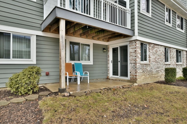 entrance to property with brick siding and a patio area