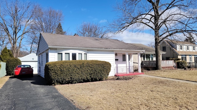 view of front of house featuring a garage, aphalt driveway, and a front yard