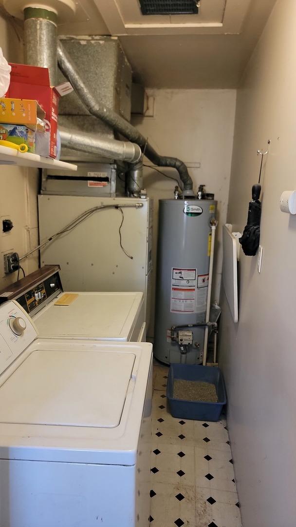 laundry area with laundry area, washer and clothes dryer, and gas water heater