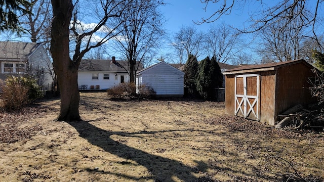 view of yard featuring a storage shed and an outbuilding