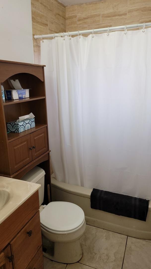 full bathroom with tile patterned flooring, shower / tub combo, toilet, and vanity