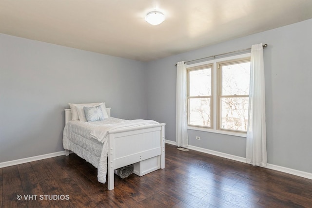 bedroom featuring dark wood finished floors, visible vents, and baseboards