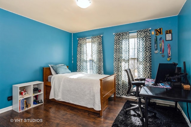 bedroom featuring baseboards, multiple windows, and wood finished floors