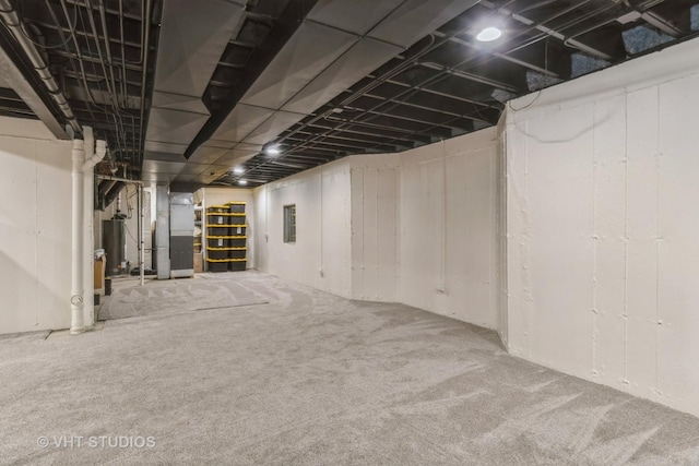 unfinished basement with heating unit, carpet, and water heater