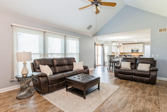 living room featuring visible vents, high vaulted ceiling, and wood finished floors