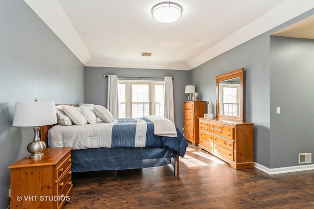 bedroom with wood finished floors, visible vents, and baseboards