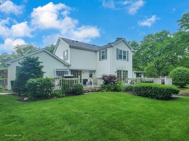 rear view of property with a deck and a lawn