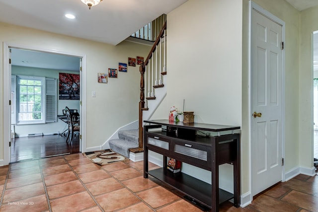 stairs with tile patterned floors, baseboards, and recessed lighting