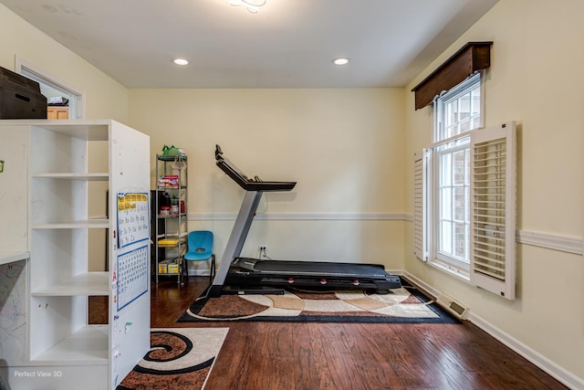 workout area featuring baseboards, wood finished floors, visible vents, and recessed lighting