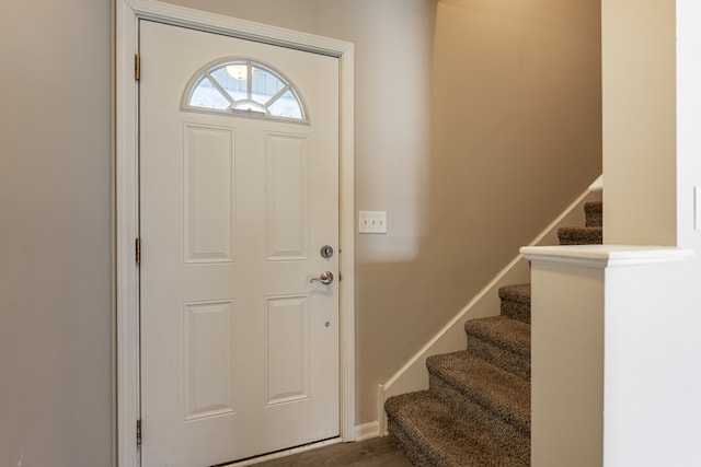 foyer featuring stairway and baseboards