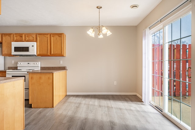 kitchen featuring decorative light fixtures, a chandelier, light wood-type flooring, white appliances, and baseboards